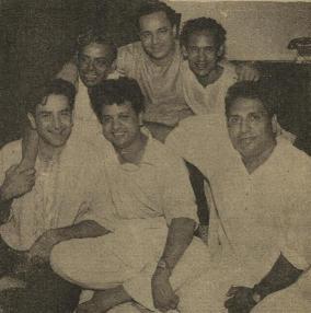 Mukesh with arms around Shailendra on one side and Hasrat Jaipuri on the other. In the front row are Raj Kapoor, Jaikishan and Shankar